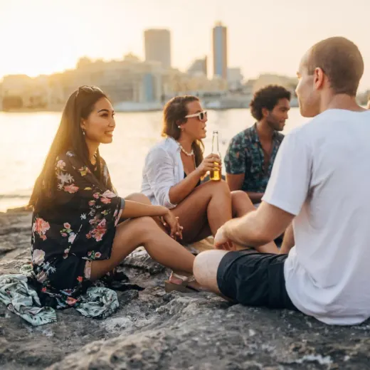 Un groupe au bord de l'eau au coucher du soleil.